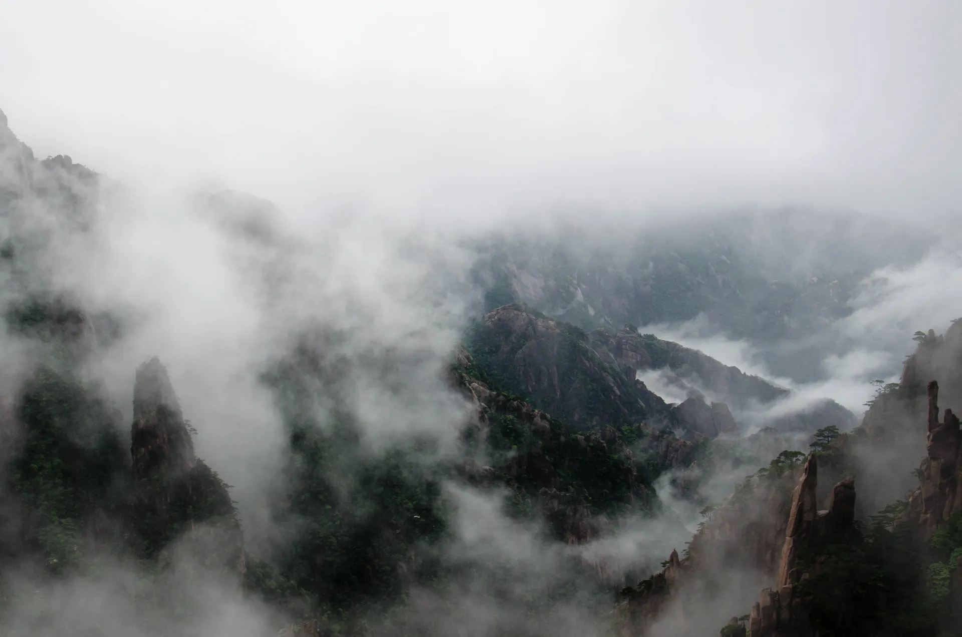 Fog filling a valley of granite peaks, one ridge standing clear of it